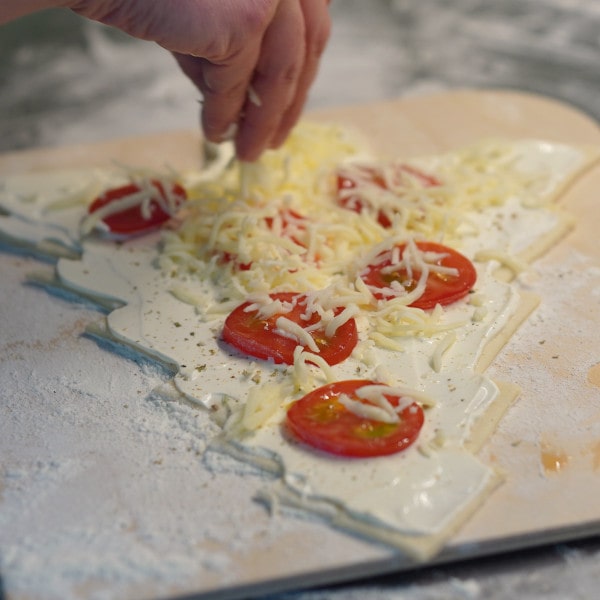 Tannenbaum Pizza mit Käse bestreuen