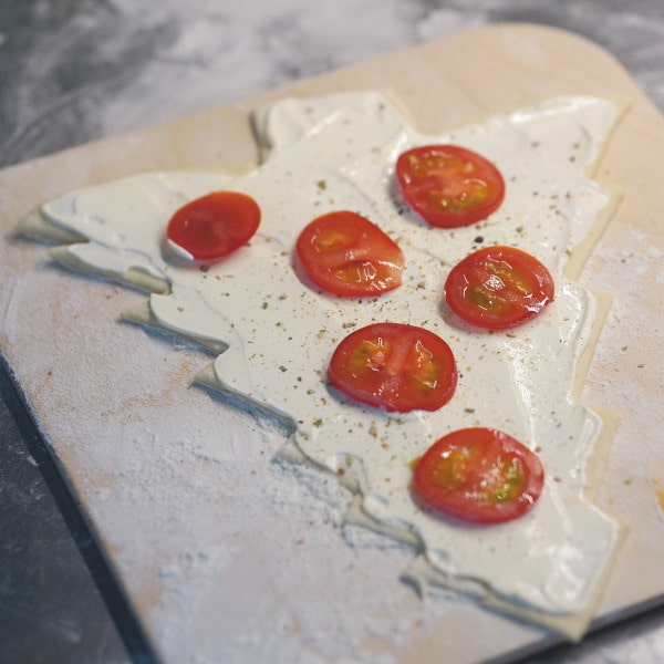 Tannenbaum Pizza mit Tomaten belegen