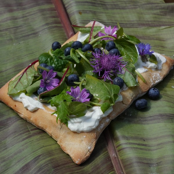 Vegetarische Pizza mit essbaren Blüten