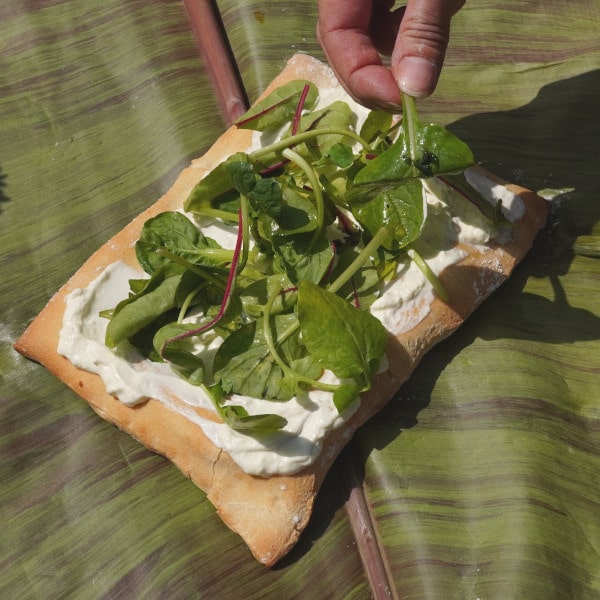 Vegetarische Pizza mit Wildkräutersalat belegen